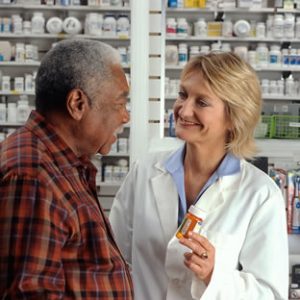 A pharmacist counsels her patient about his prescription medication.